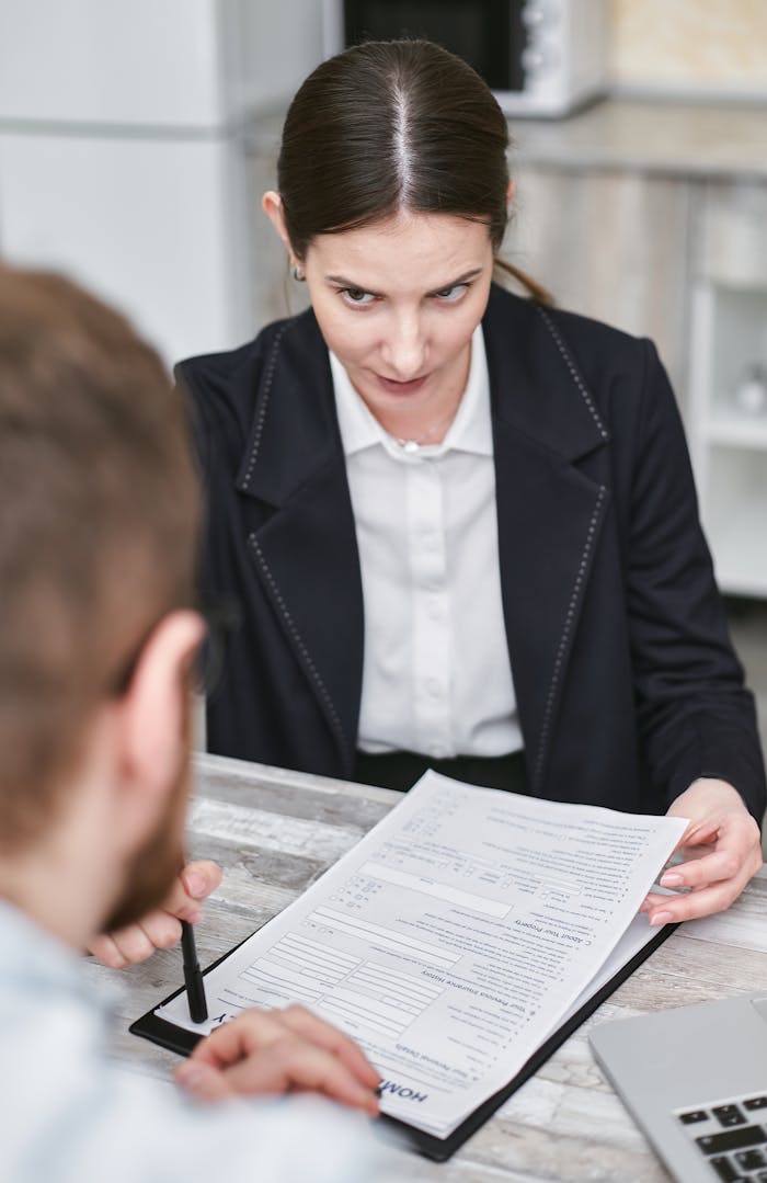 Professional business meeting with a female executive reviewing a contract with a client.